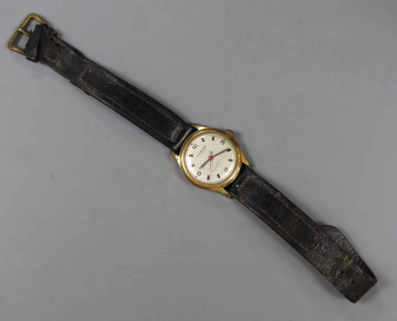 A steel and gold plated boy's size Lusina manual wind wrist watch, on leather strap.
